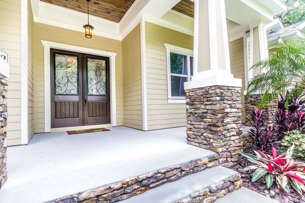 Example of a mid-sized arts and crafts beige one-story vinyl exterior home design in Tampa with a hip roof