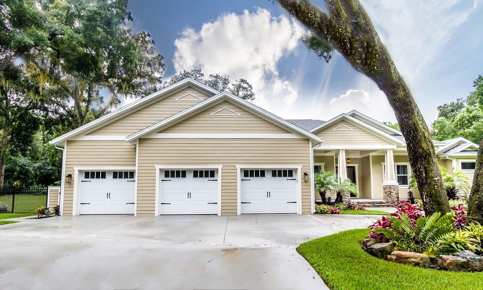 Photo of a medium sized and beige traditional bungalow house exterior in Tampa with vinyl cladding and a hip roof.