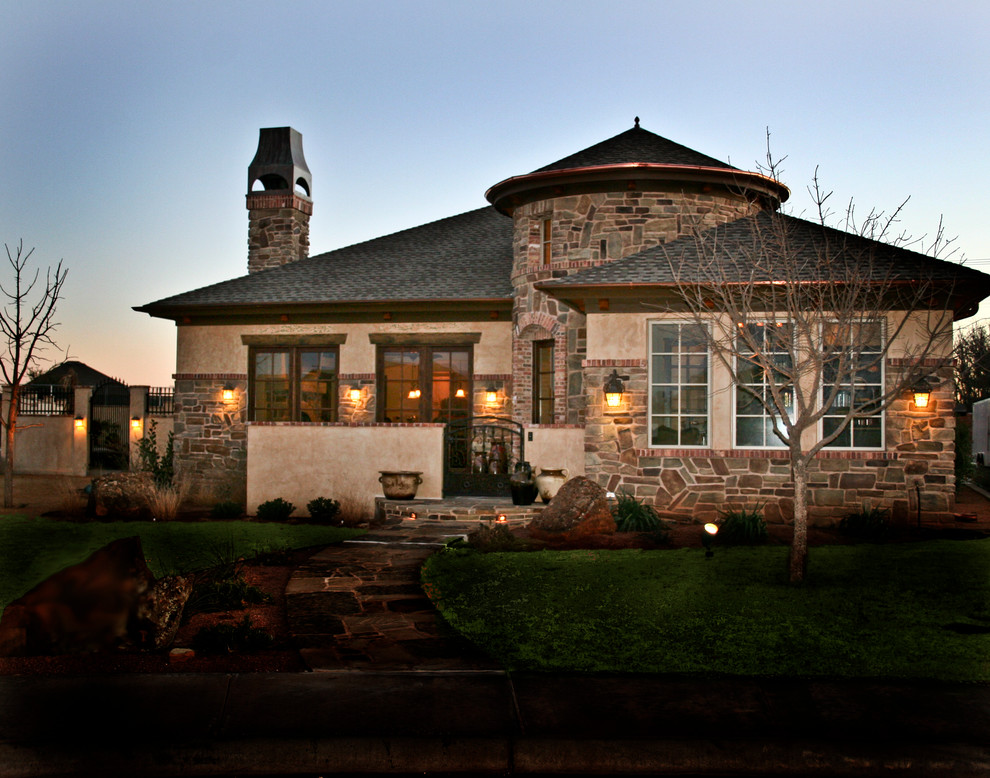 Inspiration for a mediterranean bungalow house exterior in Austin with stone cladding.