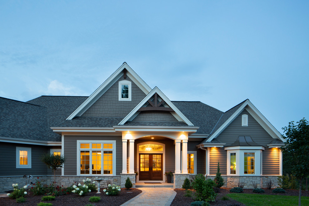 Immagine della villa grande marrone american style a un piano con rivestimenti misti, copertura mista e abbinamento di colori