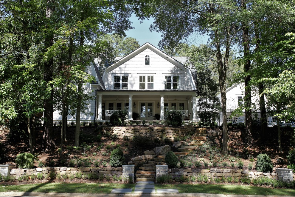 This is an example of a gey country detached house in Atlanta with wood cladding and a mansard roof.
