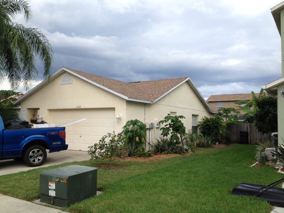 Mid-sized traditional beige one-story stucco gable roof idea in Tampa