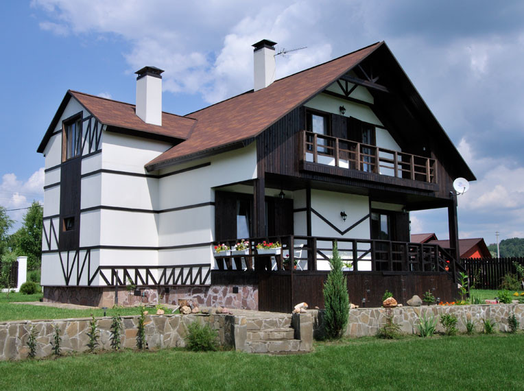 Modelo de fachada de casa blanca de estilo de casa de campo de tamaño medio de dos plantas con revestimientos combinados, tejado a doble faldón y tejado de teja de madera