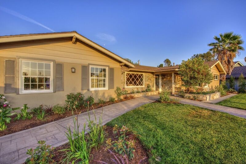 Large and beige retro bungalow house exterior in Orange County with mixed cladding and a hip roof.