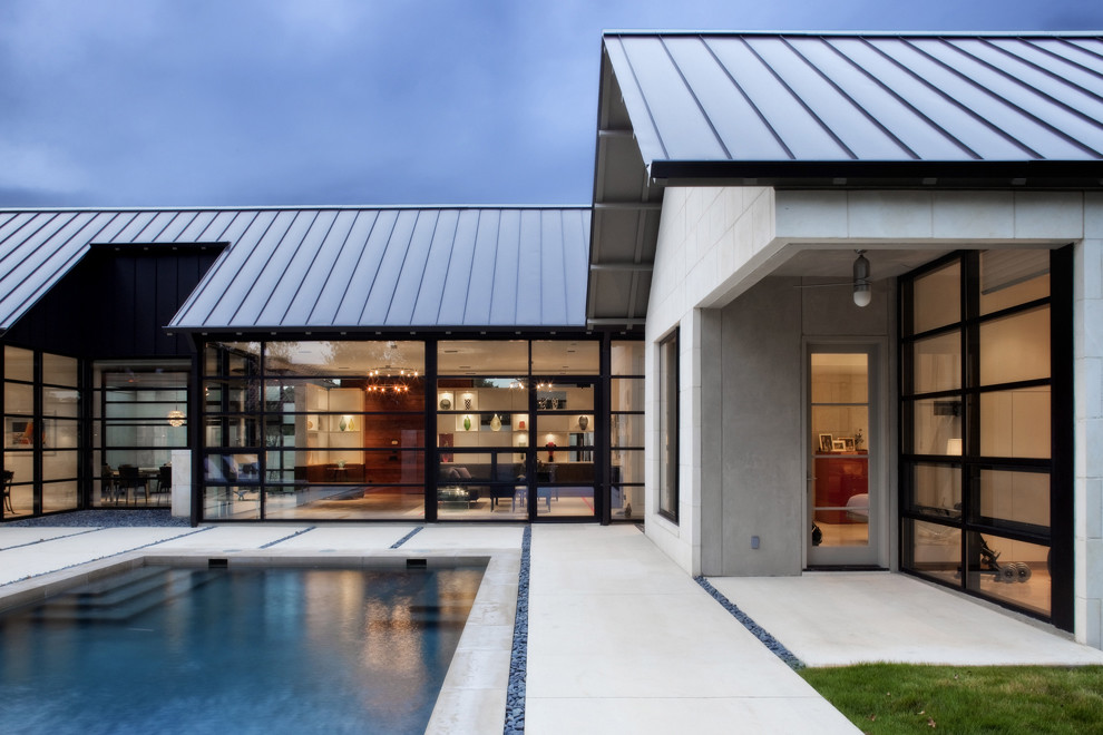 Bild på ett funkis hus, med allt i ett plan, glasfasad och tak i metall