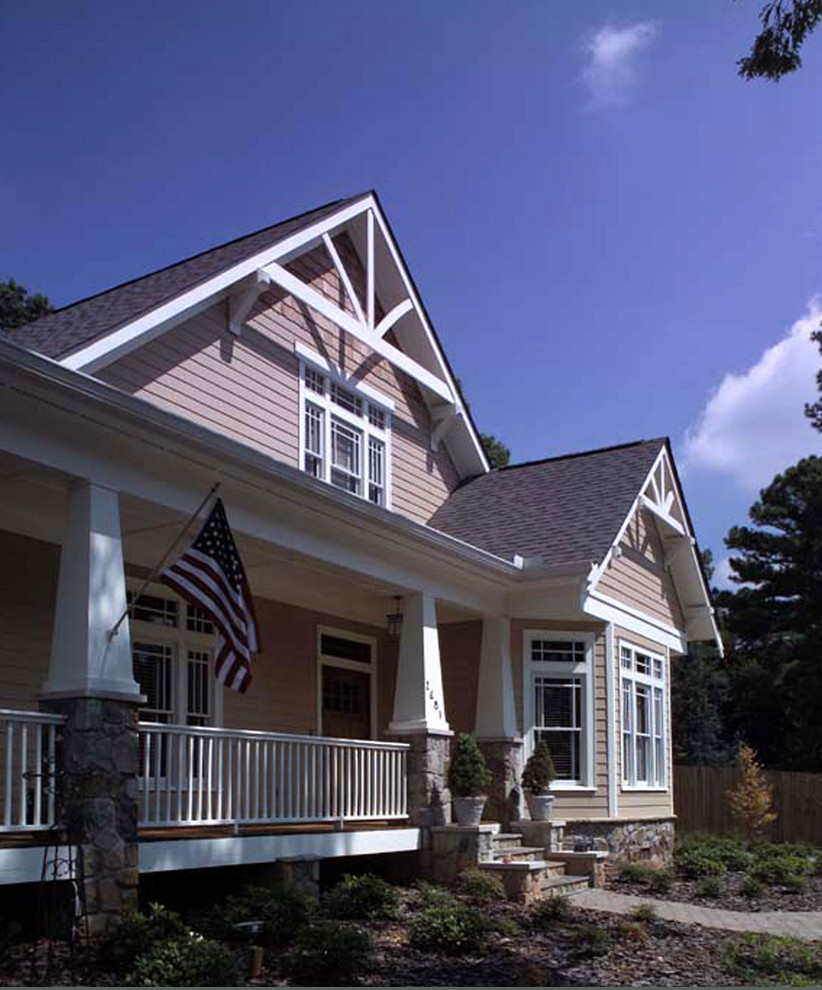 Ejemplo de fachada de casa beige de estilo americano de tamaño medio de dos plantas con tejado a dos aguas, tejado de teja de madera y revestimiento de vinilo