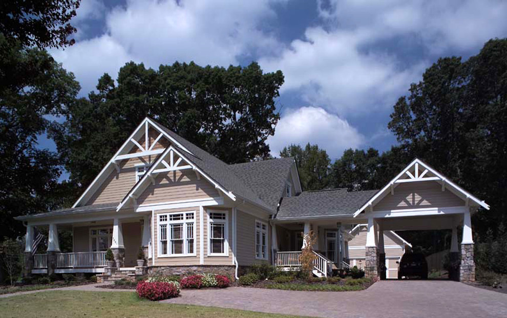 Cette photo montre une façade de maison beige craftsman de taille moyenne et à un étage avec un revêtement en vinyle, un toit à deux pans et un toit en shingle.