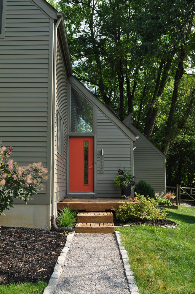 Imagen de fachada gris minimalista de dos plantas con revestimiento de madera y tejado a dos aguas