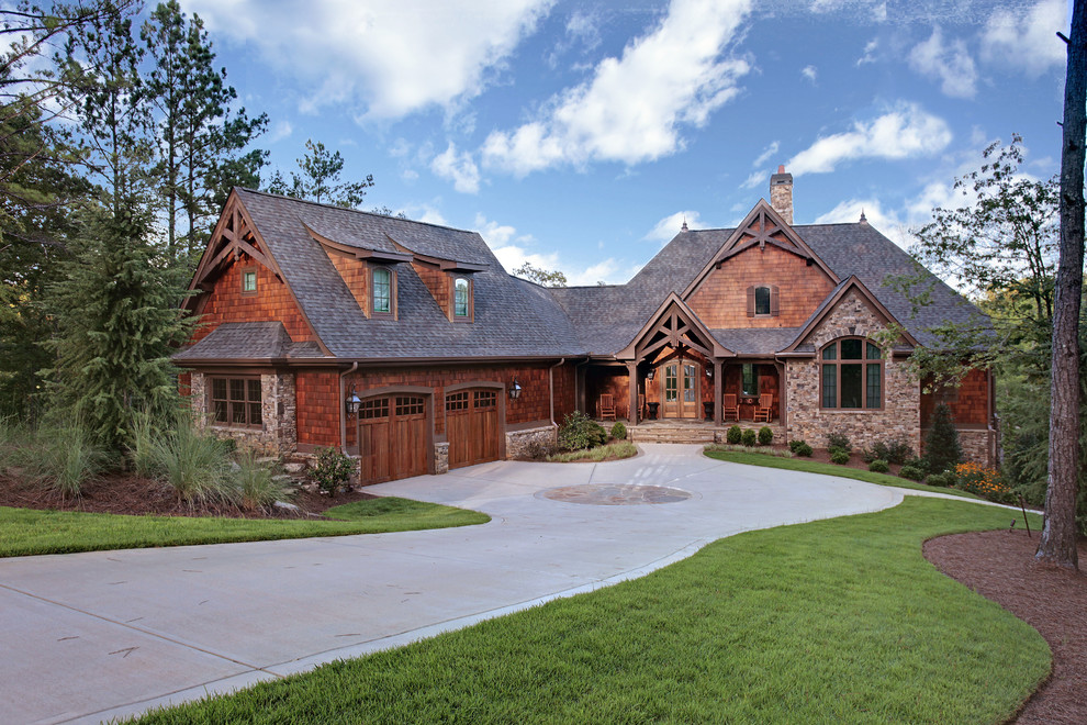 Idée de décoration pour une façade de maison marron chalet à un étage avec un revêtement mixte, un toit à croupette et un toit en shingle.