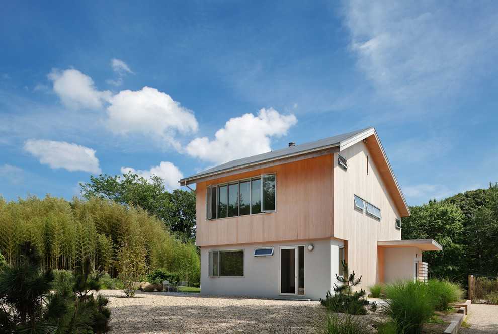 Aménagement d'une façade de maison beige contemporaine en bois de taille moyenne et à un étage.