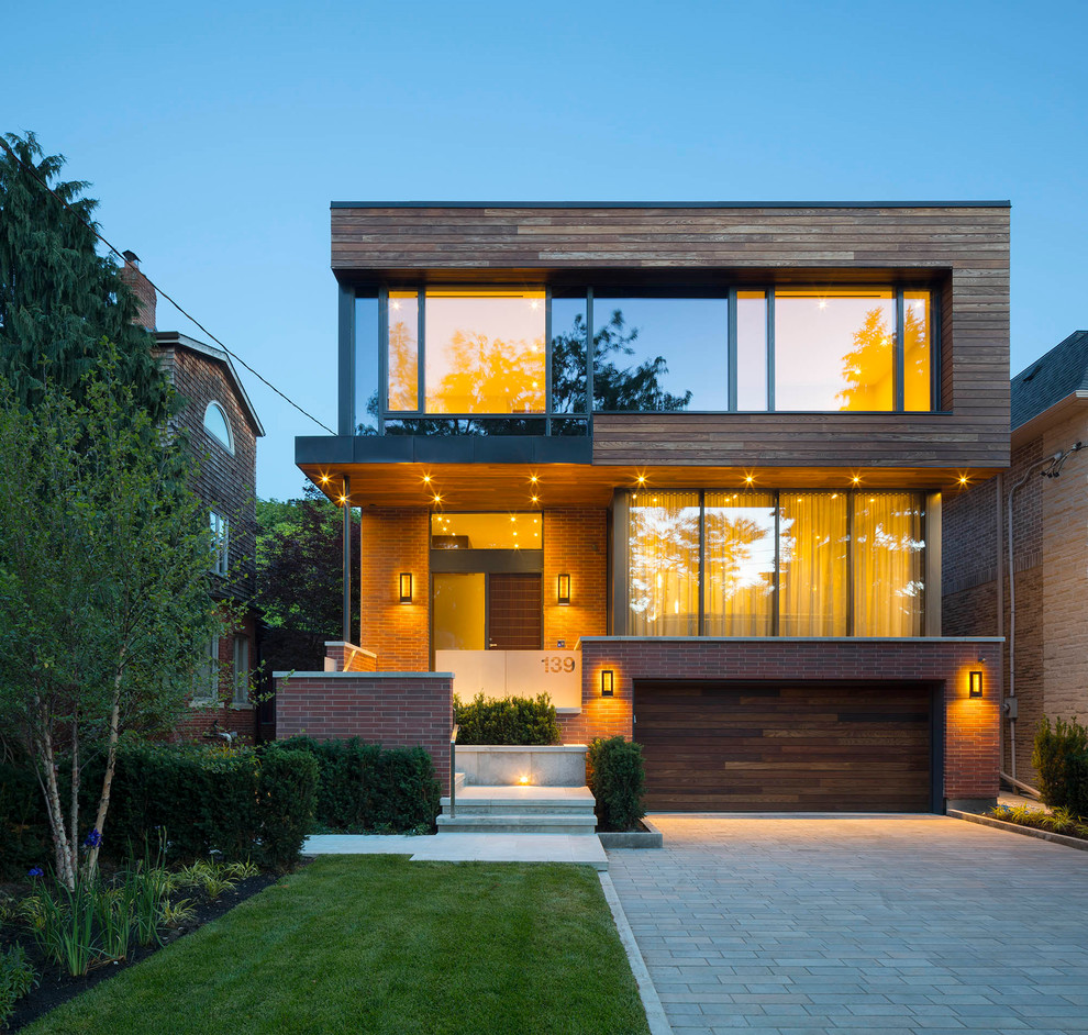 This is an example of a large and red contemporary two floor brick detached house in Toronto with a flat roof.