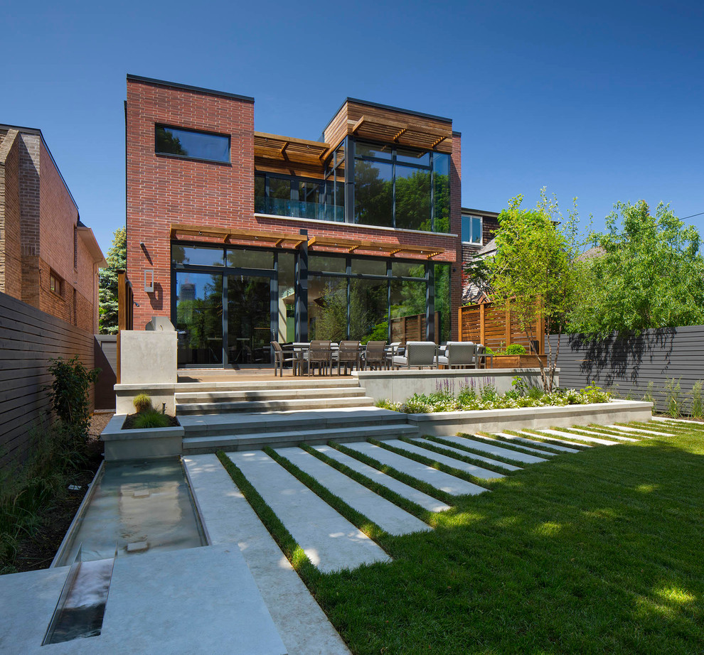 Large minimalist red two-story brick exterior home photo in Toronto