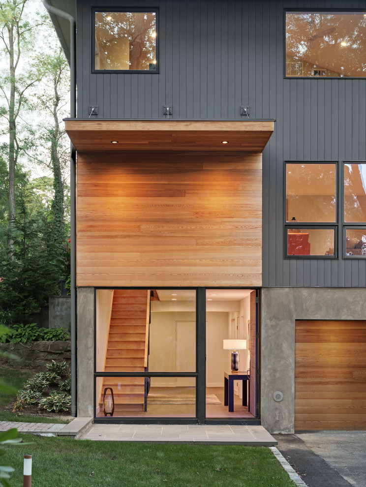 Idée de décoration pour une façade de maison grise design en bois de taille moyenne et à un étage avec un toit à quatre pans et un toit en shingle.