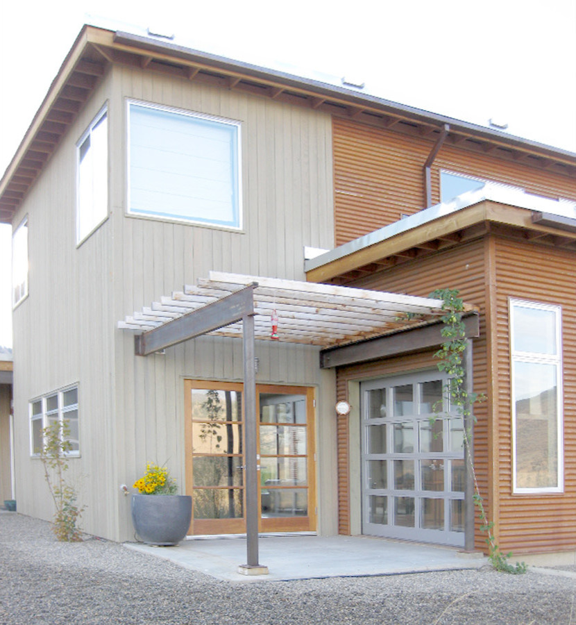 Esempio della facciata di una casa beige industriale a due piani con rivestimento in metallo