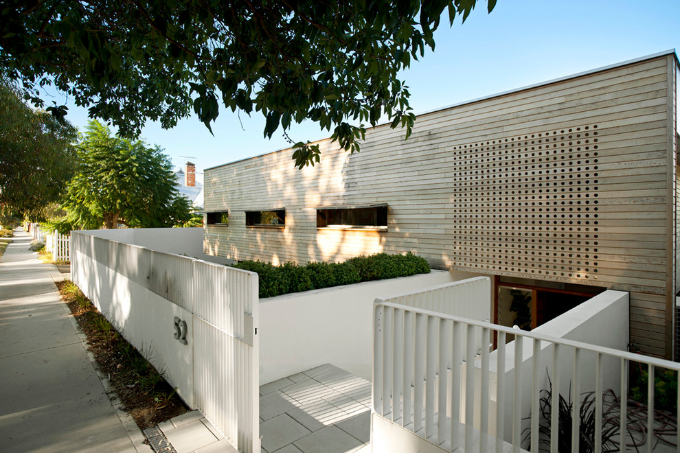 Modelo de fachada blanca contemporánea de tamaño medio a niveles con revestimiento de madera y tejado plano