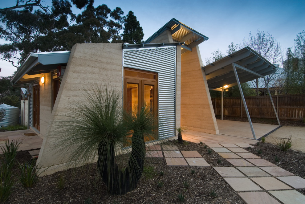 Réalisation d'une façade de maison design de taille moyenne avec un revêtement mixte et un toit en métal.