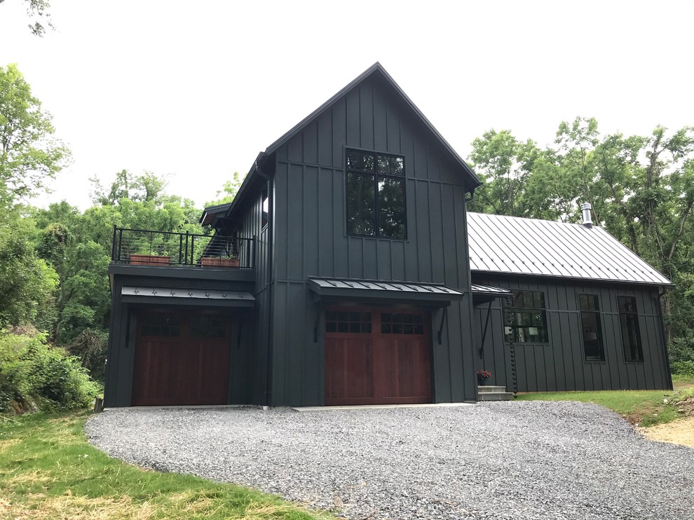 Réalisation d'une grande façade de maison grise champêtre en bois à un étage avec un toit à deux pans et un toit en métal.