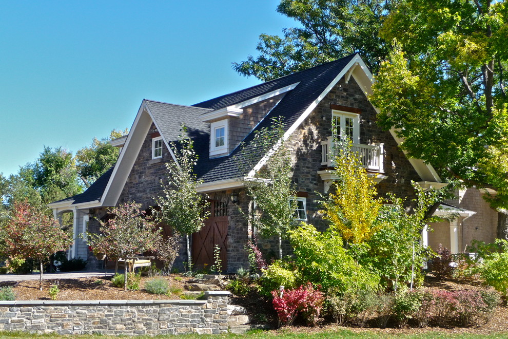 Large country gray two-story stone gable roof idea in Denver