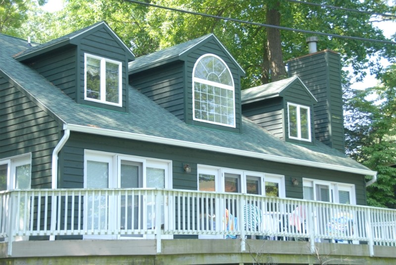 Imagen de fachada de casa verde clásica grande de dos plantas con revestimiento de madera, tejado a dos aguas y tejado de teja de madera