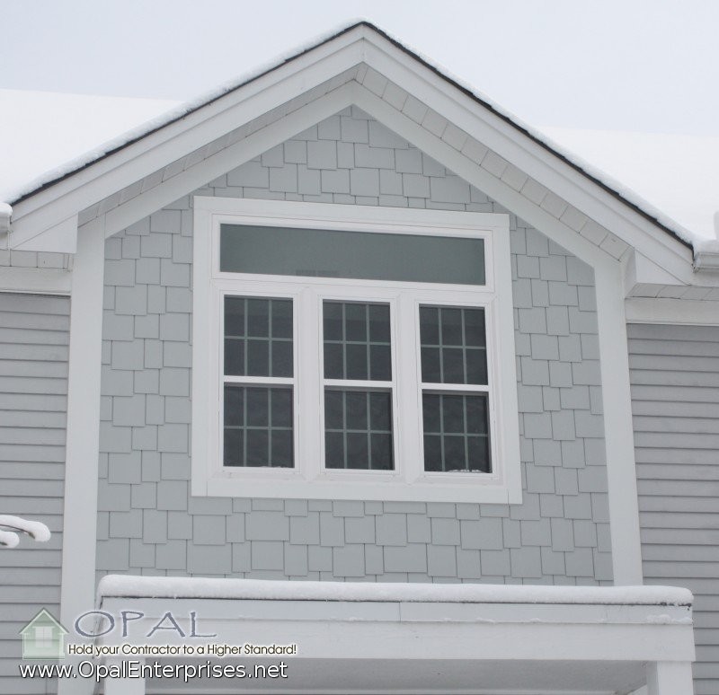 На фото: двухэтажный, серый дом среднего размера в классическом стиле с облицовкой из ЦСП