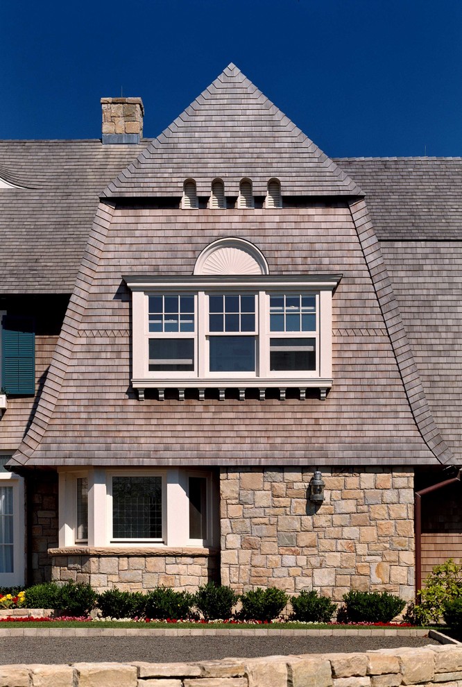Photo of a traditional house exterior in New York with wood cladding and a mansard roof.