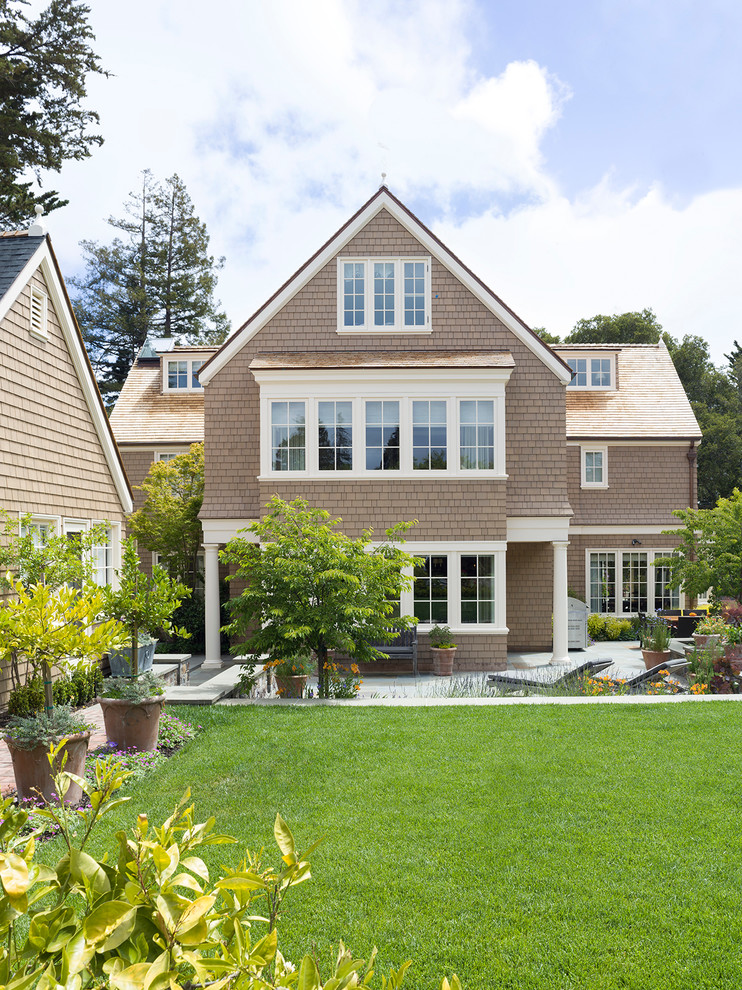 Пример оригинального дизайна: трехэтажный, деревянный, коричневый дом в викторианском стиле с двускатной крышей