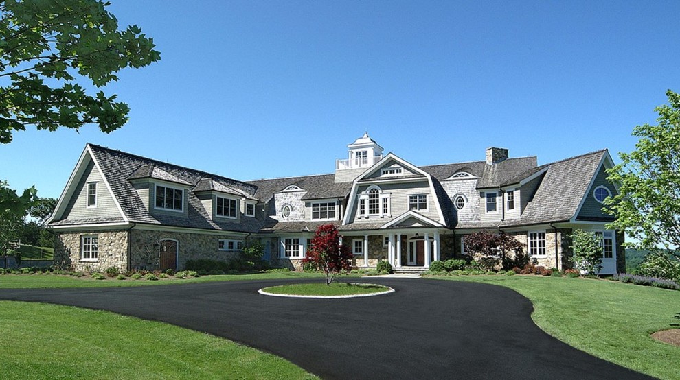Example of a huge classic gray two-story stone exterior home design in New York with a gambrel roof