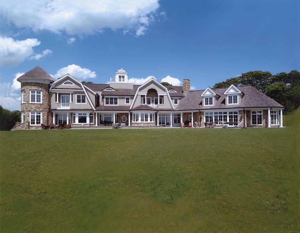 Example of a huge classic gray two-story stone exterior home design in New York with a gambrel roof