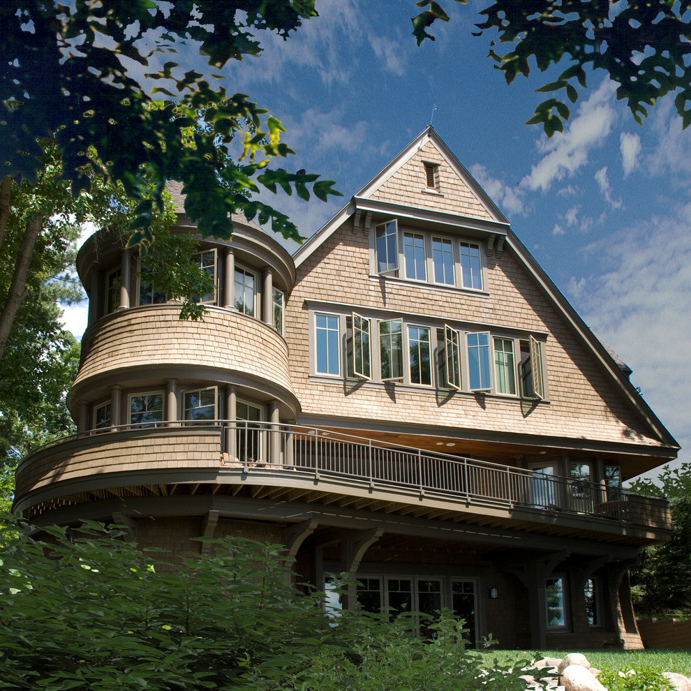 Imagen de fachada beige tradicional de tres plantas con revestimiento de madera y tejado a dos aguas
