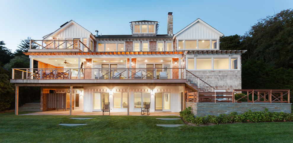 Cette photo montre une grande façade de maison marron bord de mer en bois à deux étages et plus avec un toit à deux pans.