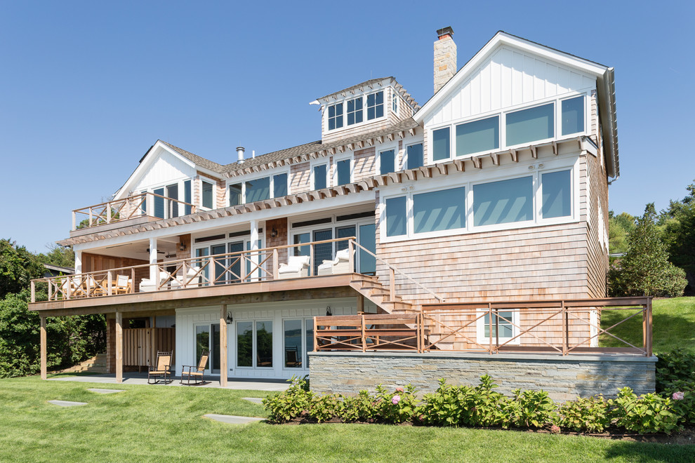 Exemple d'une grande façade de maison marron bord de mer en bois à deux étages et plus avec un toit à deux pans.