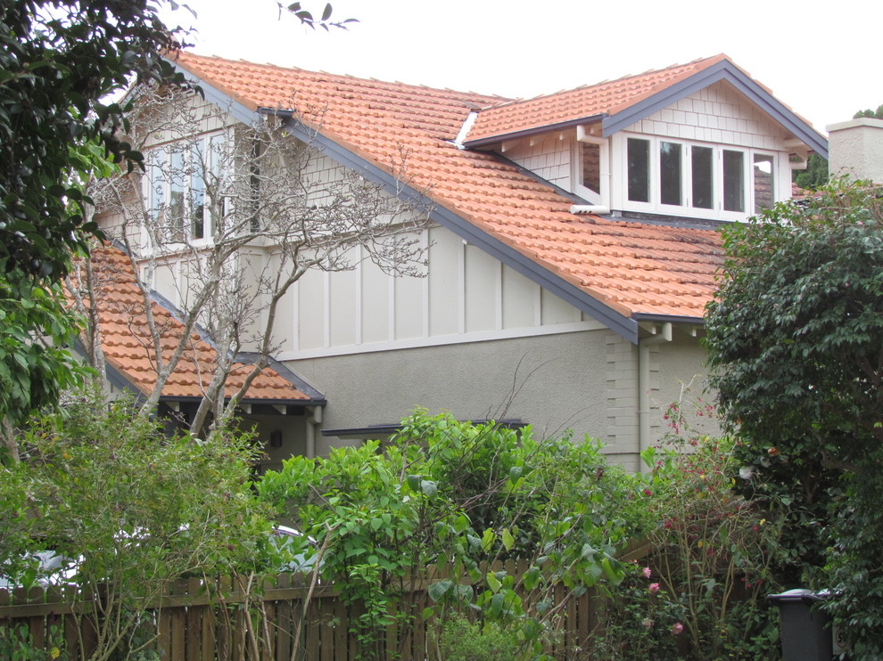 Пример оригинального дизайна: двухэтажный, бежевый дом среднего размера в классическом стиле с облицовкой из цементной штукатурки и двускатной крышей