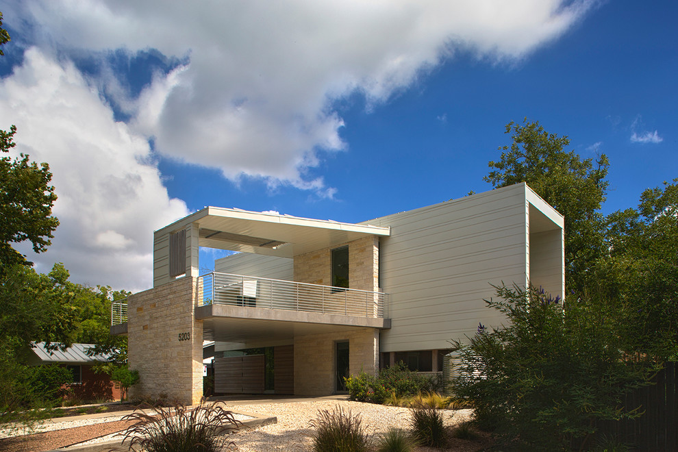 Example of a minimalist beige two-story flat roof design in Austin
