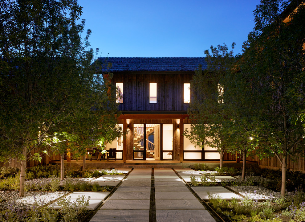 Ejemplo de fachada gris minimalista de dos plantas con revestimiento de madera