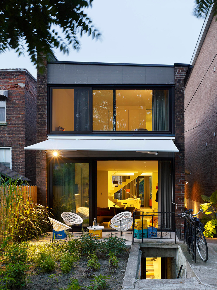 Cette image montre une petite façade de maison marron design en brique à un étage.