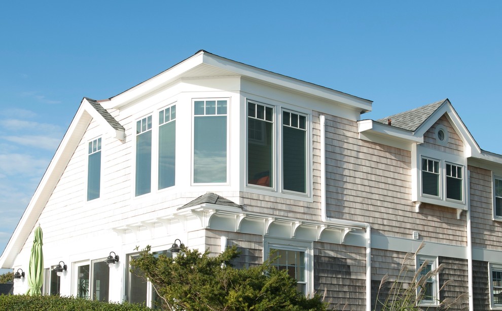 Esempio della facciata di una casa bianca eclettica a due piani di medie dimensioni con rivestimento in legno e tetto a capanna