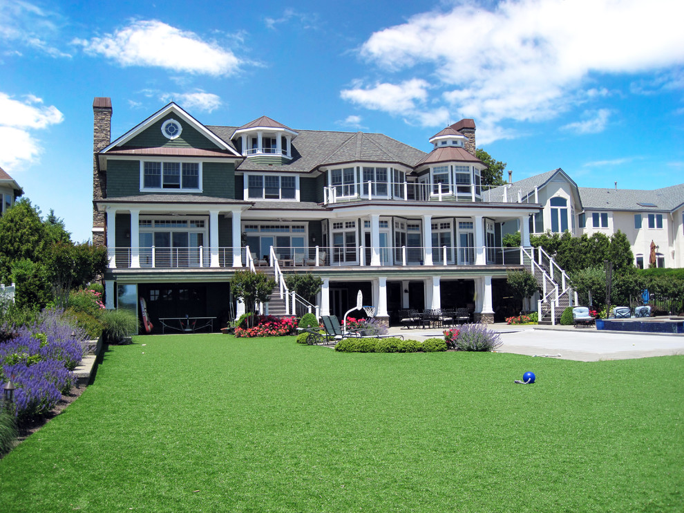 Green beach style house exterior in New York with three floors and wood cladding.