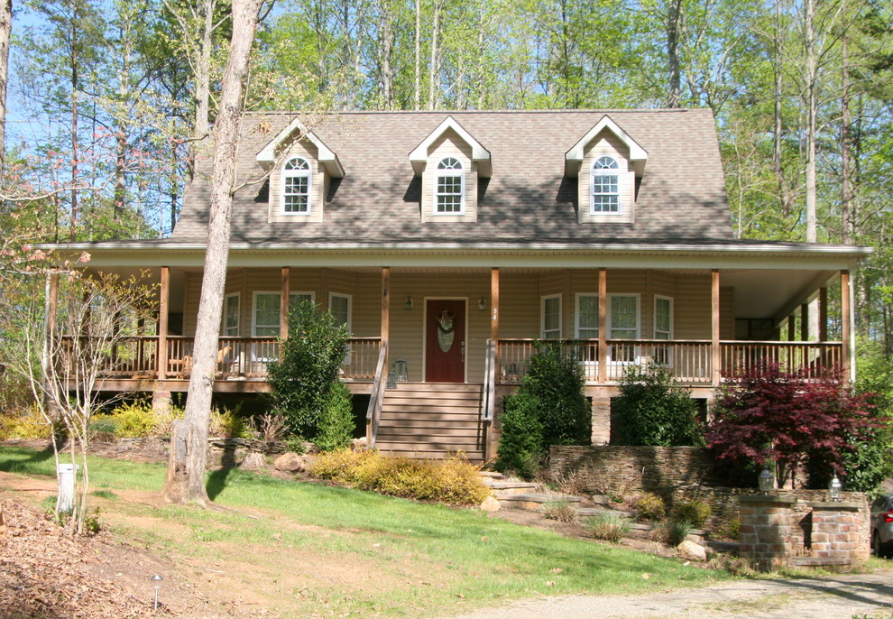 Cette photo montre une grande façade de maison beige nature à un étage avec un revêtement en vinyle et un toit à deux pans.