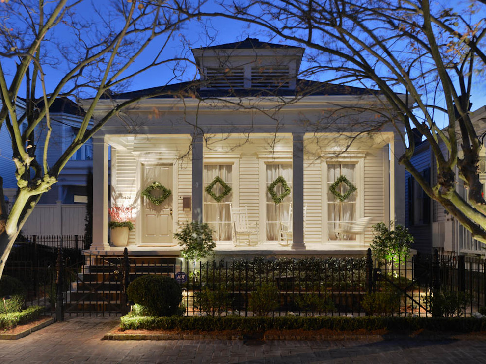 Inspiration for a mid-sized timeless white one-story wood exterior home remodel in New Orleans with a hip roof
