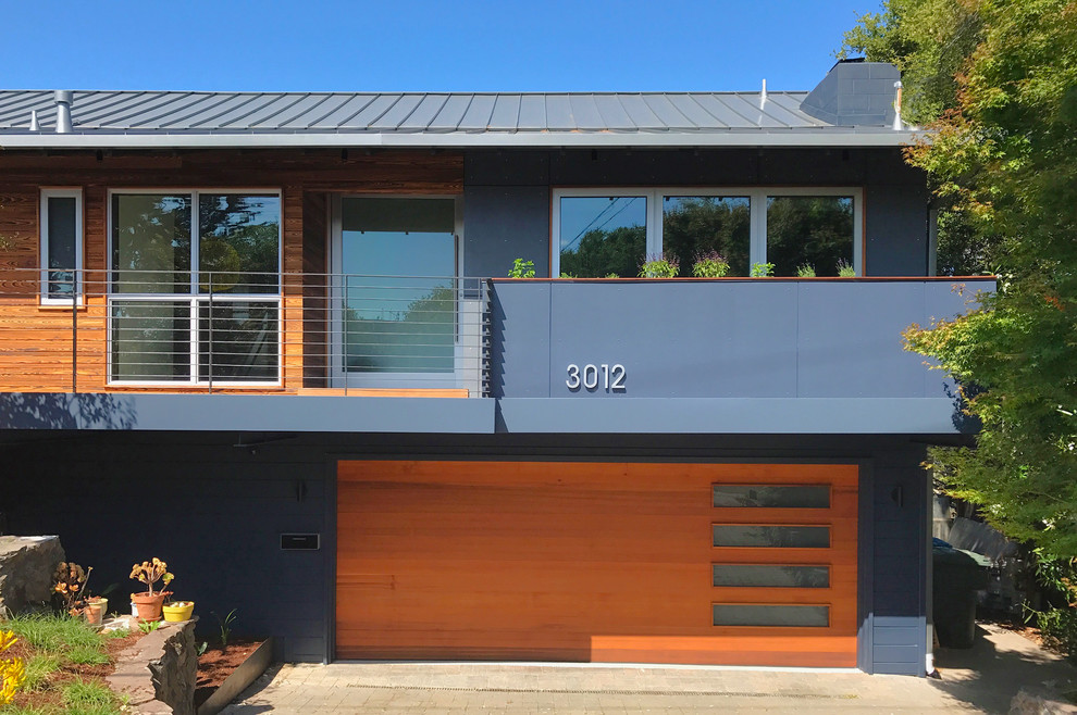 Ejemplo de fachada de casa multicolor contemporánea de dos plantas con revestimientos combinados, tejado a dos aguas y tejado de metal