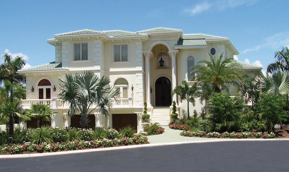 Foto de fachada de casa blanca tropical grande de tres plantas con revestimiento de estuco, tejado a cuatro aguas y tejado de metal