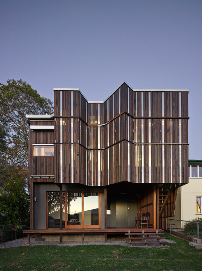 This is an example of a medium sized contemporary two floor house exterior in Brisbane with wood cladding.