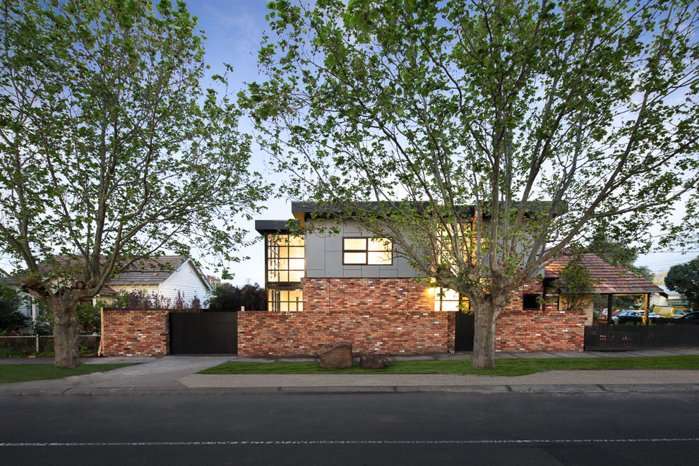 Cette image montre une façade de maison marron design en brique de taille moyenne et à un étage avec un toit à deux pans.