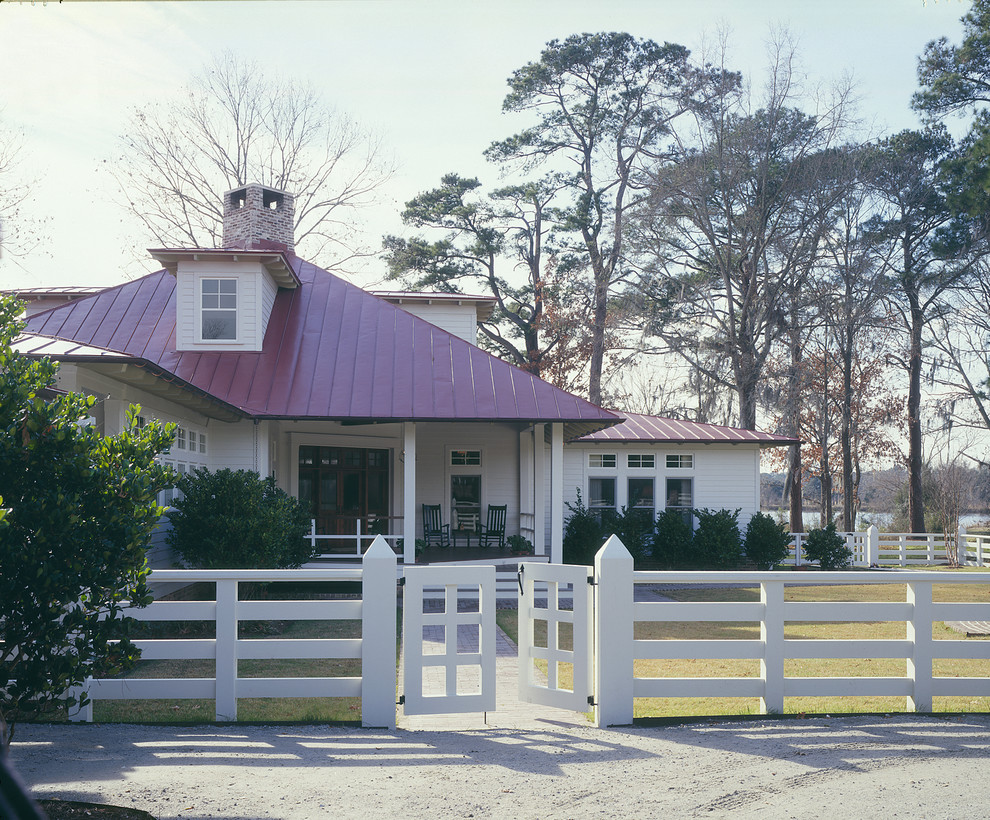 Foto de fachada blanca de estilo de casa de campo de tamaño medio de una planta con revestimiento de madera y tejado a cuatro aguas