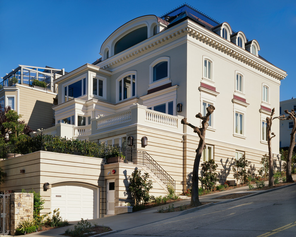Idee per la facciata di una casa grande beige classica a tre piani con rivestimento in stucco e tetto a padiglione
