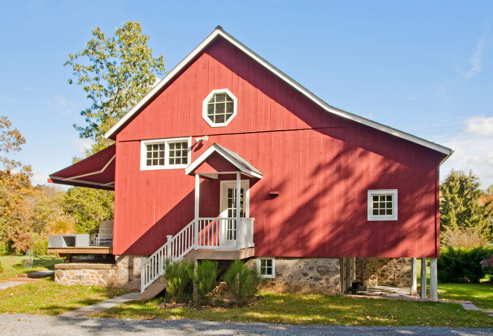 Aménagement d'une grande façade de maison rouge campagne en bois à deux étages et plus.