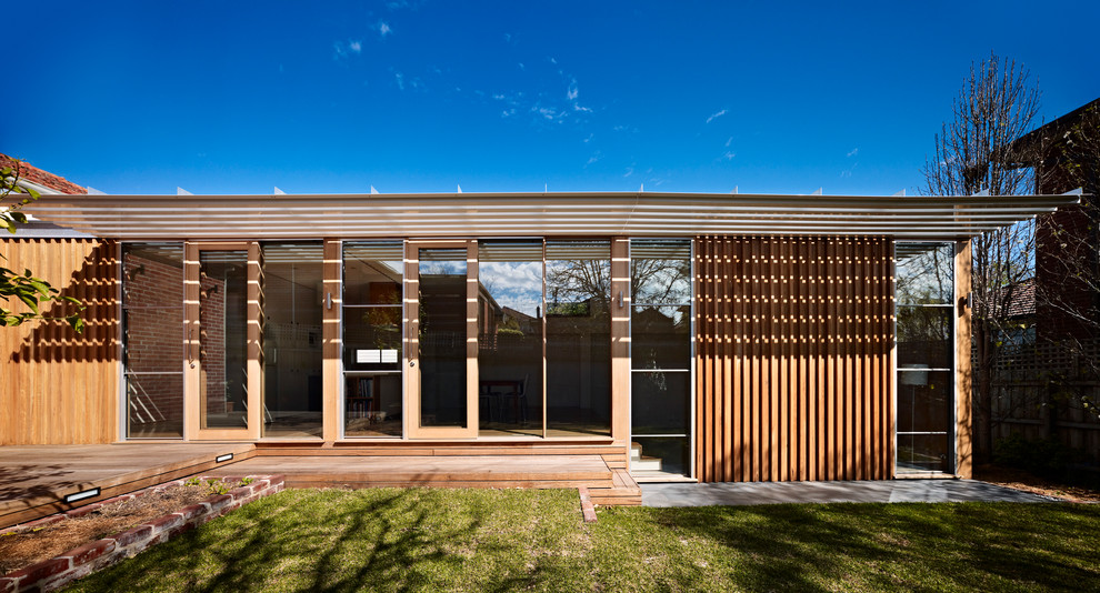 Exemple d'une façade de maison marron tendance en bois de taille moyenne et de plain-pied avec un toit plat.