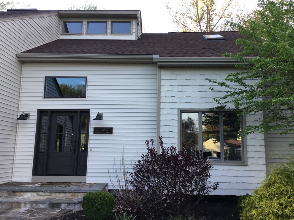 Ejemplo de fachada de casa beige de tamaño medio de dos plantas con revestimiento de vinilo