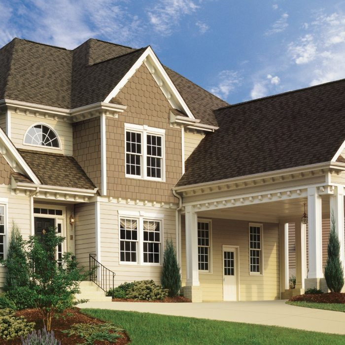 Large elegant beige two-story mixed siding house exterior photo in Other with a hip roof and a shingle roof