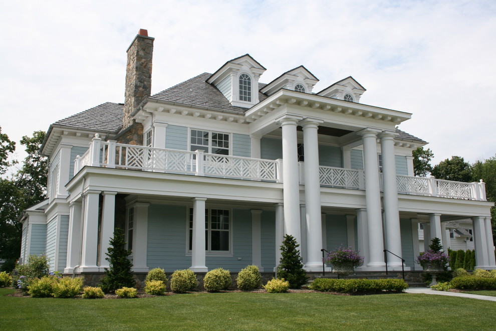Foto della facciata di una casa grande blu classica a due piani con rivestimento con lastre in cemento